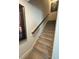 Carpeted staircase featuring decorative wall art and a wooden handrail at 829 S Franklin St, Wake Forest, NC 27587