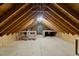 Unfinished attic space with exposed beams, natural light, and potential for customization at 8429 Bells Lake Rd, Apex, NC 27539