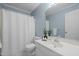 Bright bathroom featuring a vanity with a sink and faucet, a large mirror, and a shower-tub with a white shower curtain at 8429 Bells Lake Rd, Apex, NC 27539