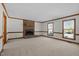 Spacious living room featuring a brick fireplace and natural light from two windows at 8429 Bells Lake Rd, Apex, NC 27539