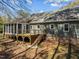 The backyard features a wooden deck with stairs, green siding, and a brick foundation, enhancing the home's outdoor appeal at 8429 Bells Lake Rd, Apex, NC 27539