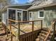 The backyard showcases a wooden deck with railing and stairs, with entry to a screened in porch at 8429 Bells Lake Rd, Apex, NC 27539