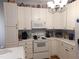 Bright kitchen with white cabinetry, white appliances, and a functional layout at 903 Teague Pl, Durham, NC 27707