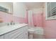 Pink tiled bathroom with white vanity, toilet, and shower-tub combo at 914 S Crescent Dr, Smithfield, NC 27577