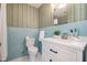 Retro bathroom with blue tile, decorative wallpaper, and updated white vanity at 914 S Crescent Dr, Smithfield, NC 27577