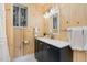 Charming bathroom featuring wood paneled walls, vanity with black cabinets, and stained glass window at 914 S Crescent Dr, Smithfield, NC 27577