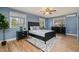 Serene bedroom with blue walls, hardwood floors, and ample natural light from three windows at 914 S Crescent Dr, Smithfield, NC 27577