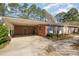 View of the brick home featuring a convenient carport, blue shutters, and well-maintained landscaping at 914 S Crescent Dr, Smithfield, NC 27577