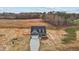 Aerial view of a cozy home with a long drive, siding, black roof, and a lush backyard at 9353 Turkey Way, Middlesex, NC 27557