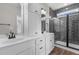 Elegant bathroom featuring double sinks, sleek cabinets, and a modern shower with gray tiling at 9353 Turkey Way, Middlesex, NC 27557