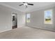 Bright bedroom with neutral colors, ceiling fan, carpet flooring, and natural light from two windows at 9353 Turkey Way, Middlesex, NC 27557