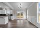Elegant dining area with hardwood floors, chandelier, wainscoting, flowing into kitchen with stainless steel appliances at 9353 Turkey Way, Middlesex, NC 27557