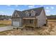 Charming two-story home with gray siding, black roof, attached garage, and inviting front porch at 9353 Turkey Way, Middlesex, NC 27557