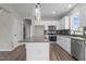 Well-lit kitchen with stainless steel appliances, granite countertops, gray backsplash, white cabinets and hardwood flooring at 9353 Turkey Way, Middlesex, NC 27557