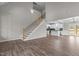 Open-concept living space with a staircase, hardwood floors, seamlessly connecting living, dining, and kitchen areas at 9353 Turkey Way, Middlesex, NC 27557