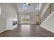 Bright living room featuring a fireplace, hardwood floors, tall windows, and a staircase, offering modern comfort at 9353 Turkey Way, Middlesex, NC 27557