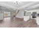 Open-concept living area with hardwood floors, staircase, white kitchen with black backsplash and modern pendant lighting at 9353 Turkey Way, Middlesex, NC 27557