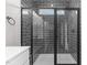 Modern shower with dark gray tiling, glass door, rainfall shower head, and convenient built-in bench at 9353 Turkey Way, Middlesex, NC 27557