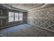 Unfinished bedroom with decorative wood accent wall and a large window overlooking a wooded view at 98 Fox Oak Trl, Pittsboro, NC 27312