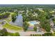 Community aerial view featuring a lake with a fountain, a swimming pool, mature trees, and lush landscaping at 101 Listokin Ct, Cary, NC 27519