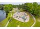 Aerial view of a large playground area featuring multiple slides and play equipment near a tranquil lake at 101 Listokin Ct, Cary, NC 27519