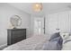 Cozy bedroom featuring a dresser, round mirror, decorative light fixture, and soft textures at 101 Listokin Ct, Cary, NC 27519