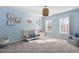 Light blue bedroom featuring a crib, modern lighting fixture, and gray armchair at 101 Listokin Ct, Cary, NC 27519