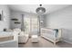 Neutral Bedroom with a crib, comfy chair, sheep wallpaper, large window, and modern light at 101 Listokin Ct, Cary, NC 27519