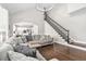 Spacious living room with a staircase, hardwood floors, and seamless access to kitchen at 101 Listokin Ct, Cary, NC 27519