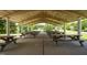 Covered outdoor picnic area with rows of wooden picnic tables and a view of a serene lake at 101 Listokin Ct, Cary, NC 27519