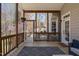 Exterior view of the covered porch, showcasing its wooden railing, patterned rug, and blooming plants at 101 Listokin Ct, Cary, NC 27519