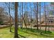Expansive backyard featuring lush green lawn, trees, and tranquil pond views creating a serene outdoor space at 102 Battenburg Ct, Cary, NC 27519
