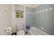 Bathroom with a tub, toilet, and window providing natural light, perfect for relaxation and functionality at 102 Battenburg Ct, Cary, NC 27519