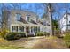 Inviting home with a covered porch, manicured bushes, and a lovely stone pathway at 102 Battenburg Ct, Cary, NC 27519