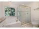 Bright main bathroom featuring a glass shower, a jacuzzi tub, and a large window at 102 Battenburg Ct, Cary, NC 27519