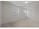 Cozy carpeted bedroom with two windows, white walls and a door to the adjacent room at 105 Concordia Woods Dr, Morrisville, NC 27560