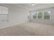 Bright bedroom featuring neutral carpet, white walls, natural light from multiple windows and white trim at 105 Concordia Woods Dr, Morrisville, NC 27560