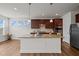 Bright kitchen featuring an island with granite counters, stainless appliances, and abundant cherry cabinets at 105 Concordia Woods Dr, Morrisville, NC 27560