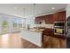Well-lit kitchen with granite countertops on island, stainless appliances, and access to backyard at 105 Concordia Woods Dr, Morrisville, NC 27560