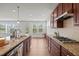 Close-up of kitchen featuring granite countertops, stainless appliances, and tile backsplash at 105 Concordia Woods Dr, Morrisville, NC 27560