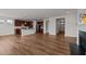 Open-concept living room featuring wood floors, a fireplace, and a kitchen island with pendant lighting at 105 Concordia Woods Dr, Morrisville, NC 27560