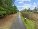 Asphalt path surrounded by trees and greenery on either side, offering a serene walking or biking experience at 105 Concordia Woods Dr, Morrisville, NC 27560