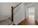 Elegant staircase featuring wooden banister and hardwood floors leading to a sunny room at 105 Concordia Woods Dr, Morrisville, NC 27560