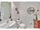 Stylish half bathroom features a pedestal sink, modern toilet, and decorative accents at 10707 Edmundson Ave, Raleigh, NC 27614