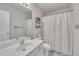Well-lit bathroom showcasing a vanity, toilet, mirror, and shower with neutral-toned curtains at 10707 Edmundson Ave, Raleigh, NC 27614