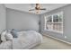 Comfortable bedroom with a ceiling fan, side window, and bed with plush pillows at 10707 Edmundson Ave, Raleigh, NC 27614