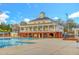 Large community clubhouse with a brick foundation and second-story veranda overlooking the pool at 10707 Edmundson Ave, Raleigh, NC 27614