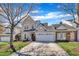 Two-story home with gray siding, brick accents, a two-car garage, and a well-manicured lawn at 10707 Edmundson Ave, Raleigh, NC 27614