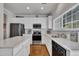 Bright kitchen features stainless steel appliances, an island, white cabinets and granite countertops at 10707 Edmundson Ave, Raleigh, NC 27614