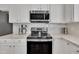 Updated kitchen features stainless steel appliances, decorative backsplash, and elegant white cabinetry at 10707 Edmundson Ave, Raleigh, NC 27614